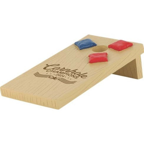 Miniature light wood cornhole board award, 4"x8"x2", with "Cornhole Champions 2024" text and red/blue bags.
