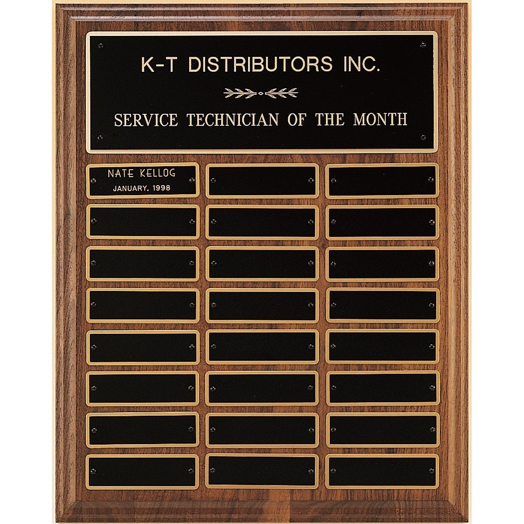 American walnut perpetual plaque with 24 black brass plates, "K-T DISTRIBUTORS INC." engraved at top.