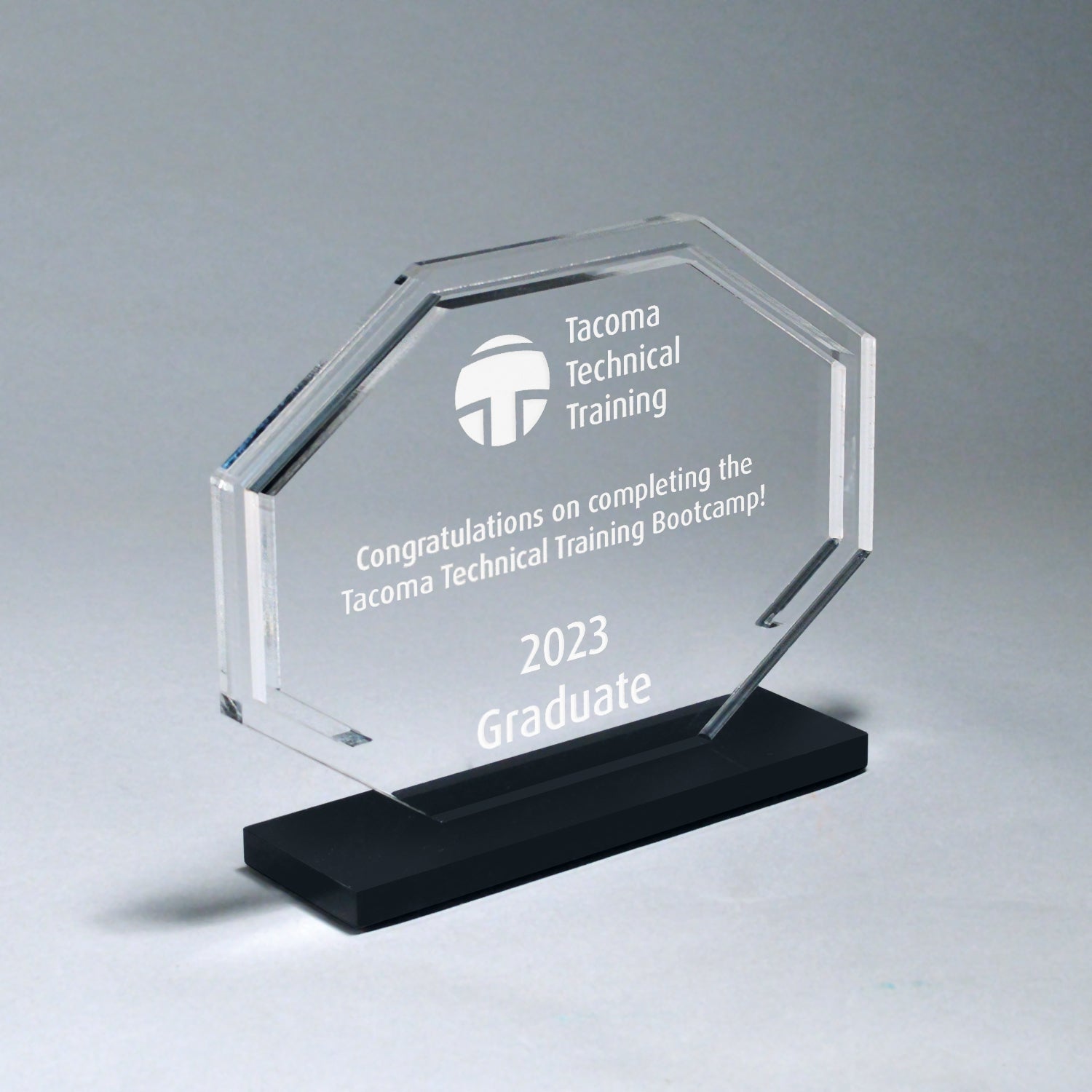 Clear acrylic octagon award with laser-etched text on a black high-luster acrylic base.