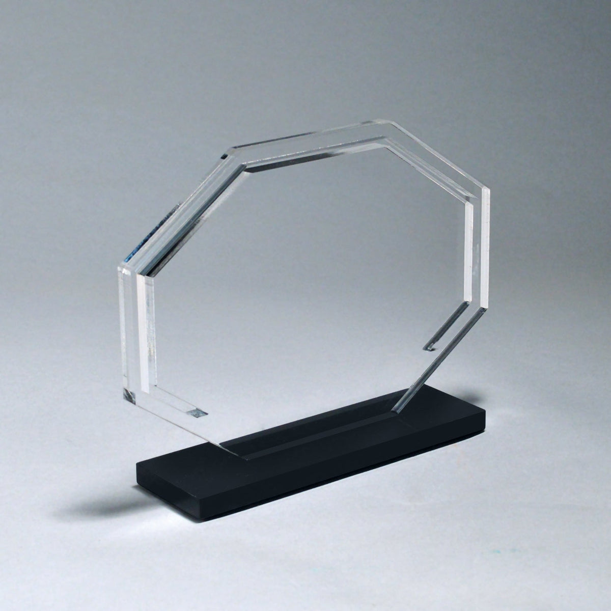 Clear acrylic octagon award with a laser-etched design, mounted on a high-luster black acrylic base.