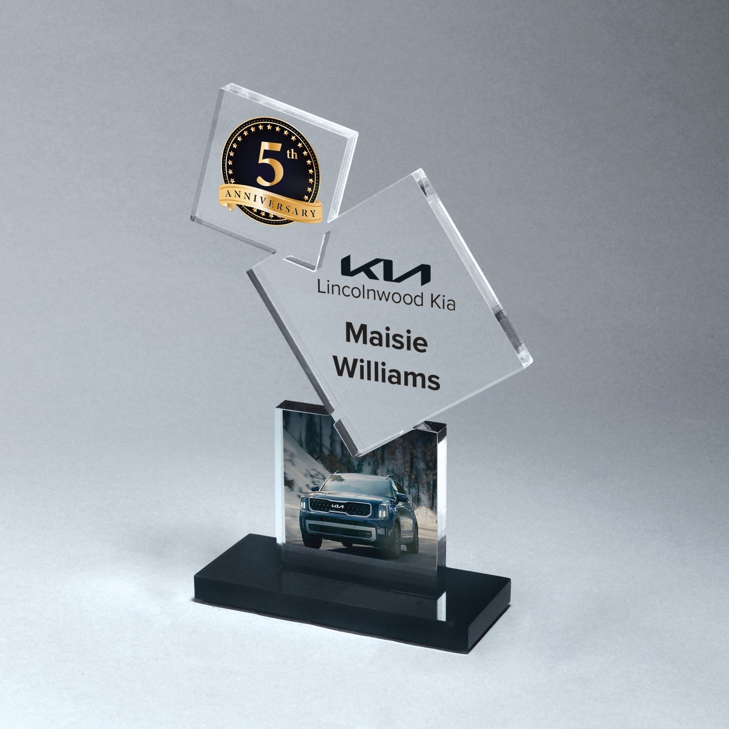 Clear stacked block award with etched 5th Anniversary logo, Kia Lincolnwood branding, car image, and black acrylic base.