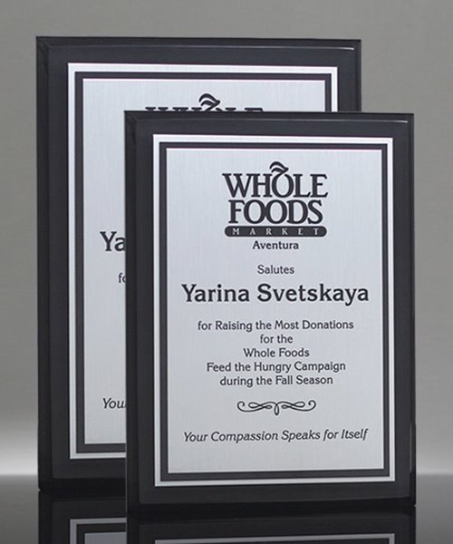 Two ebony finish wooden plaques with silver aluminum plates, one larger behind a smaller one.