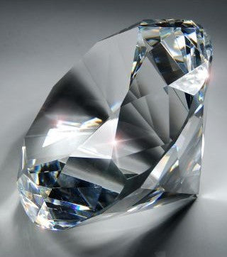 Clear, faceted octagon 4" diamond crystal paperweight with brilliant light reflections.