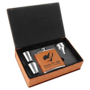 Tan laserable leatherette flask gift set with two shot glasses and a funnel in an open black box.