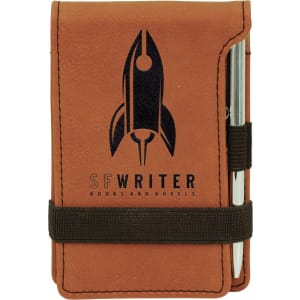 Tan leatherette mini notepad (3 1/4" x 4 3/4") with a black rocket logo, pen, and elastic band.