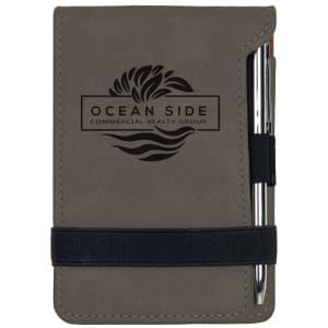Gray laserable leatherette mini notepad (3 1/4" x 4 3/4") with pen, elastic band, and custom logo.