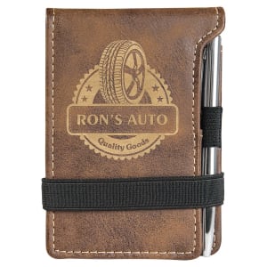 Brown laserable leatherette mini notepad with "Ron's Auto" logo, pen, and black elastic band.