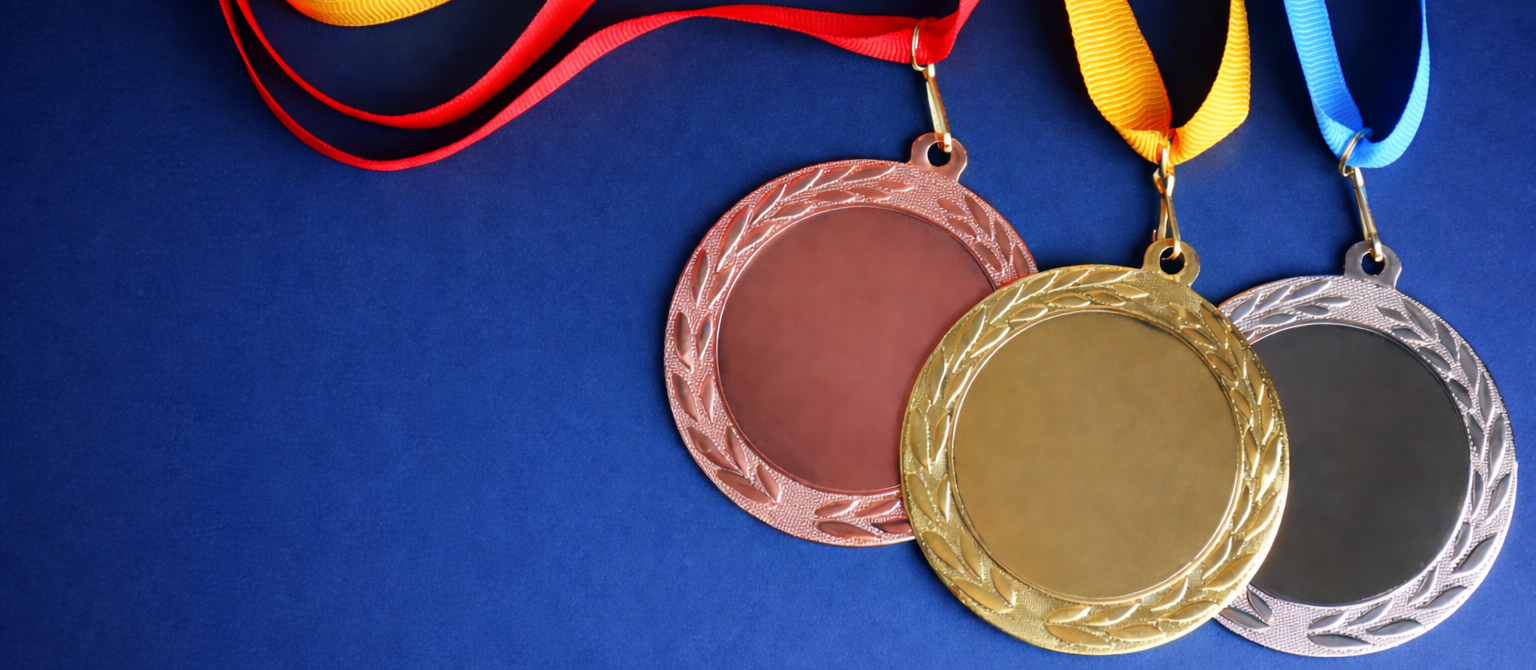 Gold, silver, and bronze medals with colorful ribbons on a blue background