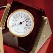 Red desk clock and thermometer with a gold-rimmed white face and black markings.
