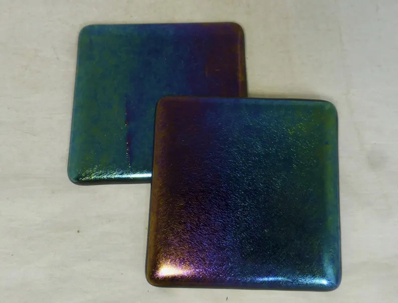 Two square 4x4 glass coasters with iridescent purple and green hues.