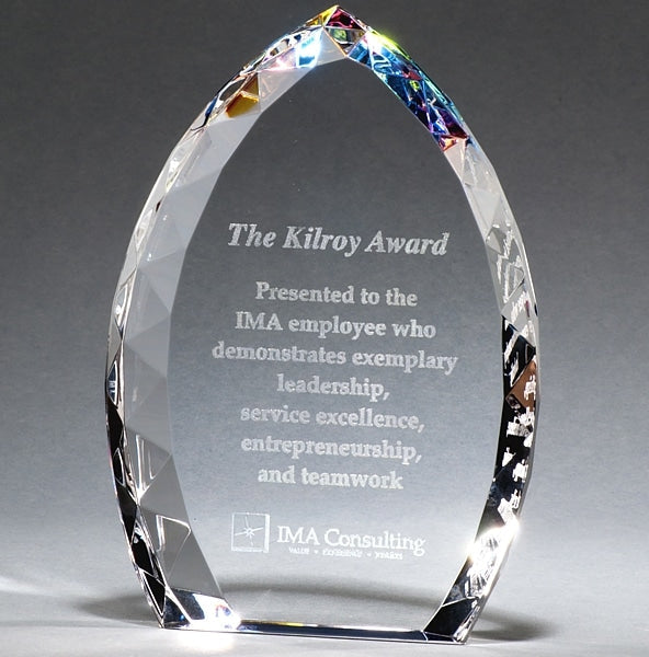 Clear crystal flame award with faceted edges and rainbow top, engraved with text.