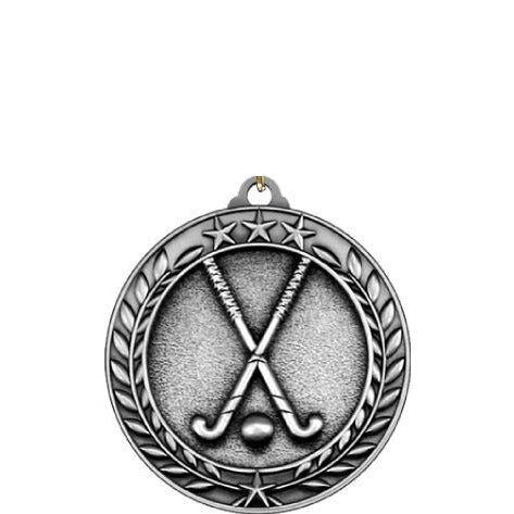 Silver antique Qualicast medallion with crossed field hockey sticks, ball, and laurel wreath.