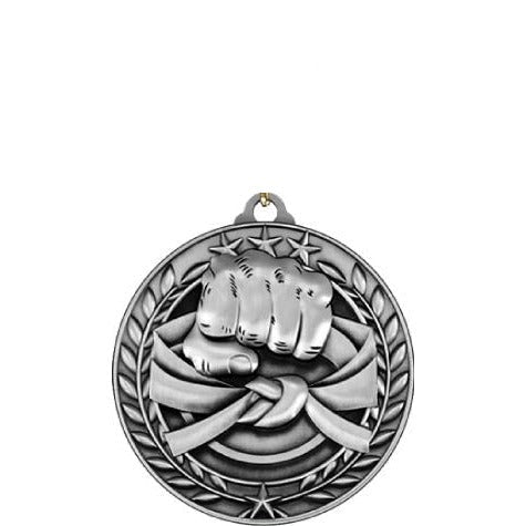 Silver antique Qualicast medallion with a raised fist, martial arts belt, stars, and wreath design.
