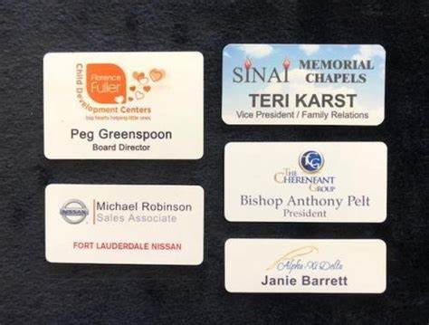 White plastic name badges with rounded corners, custom logos, and text.
