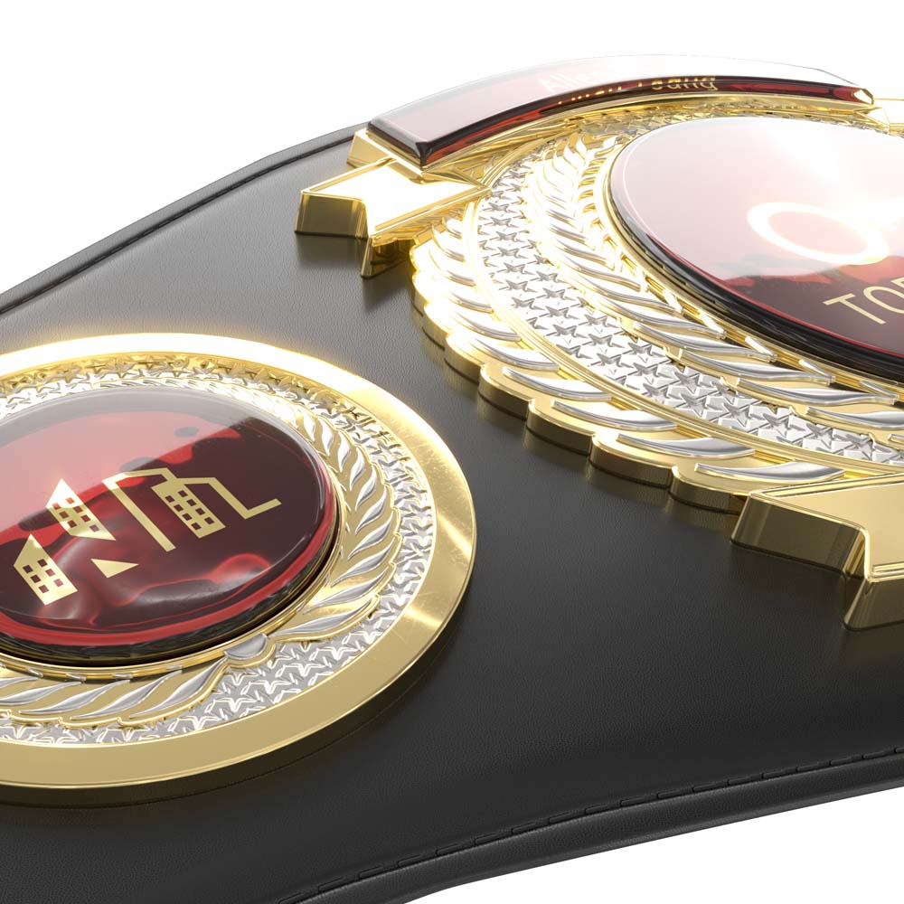 Black leather championship belt with two gold and silver medallions and red accents.