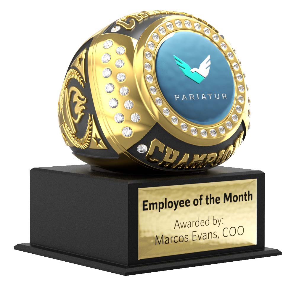 Gold and black Mega Ring award with clear gems, a blue "Pariatur" logo, and "CHAMPION" text, on a black base with a gold "Employee of the Month" plaque.