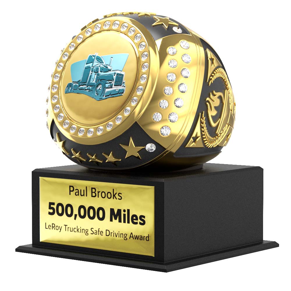 Gold and black Mega Ring award with a blue truck logo, surrounded by diamonds and stars, on a personalized black base.